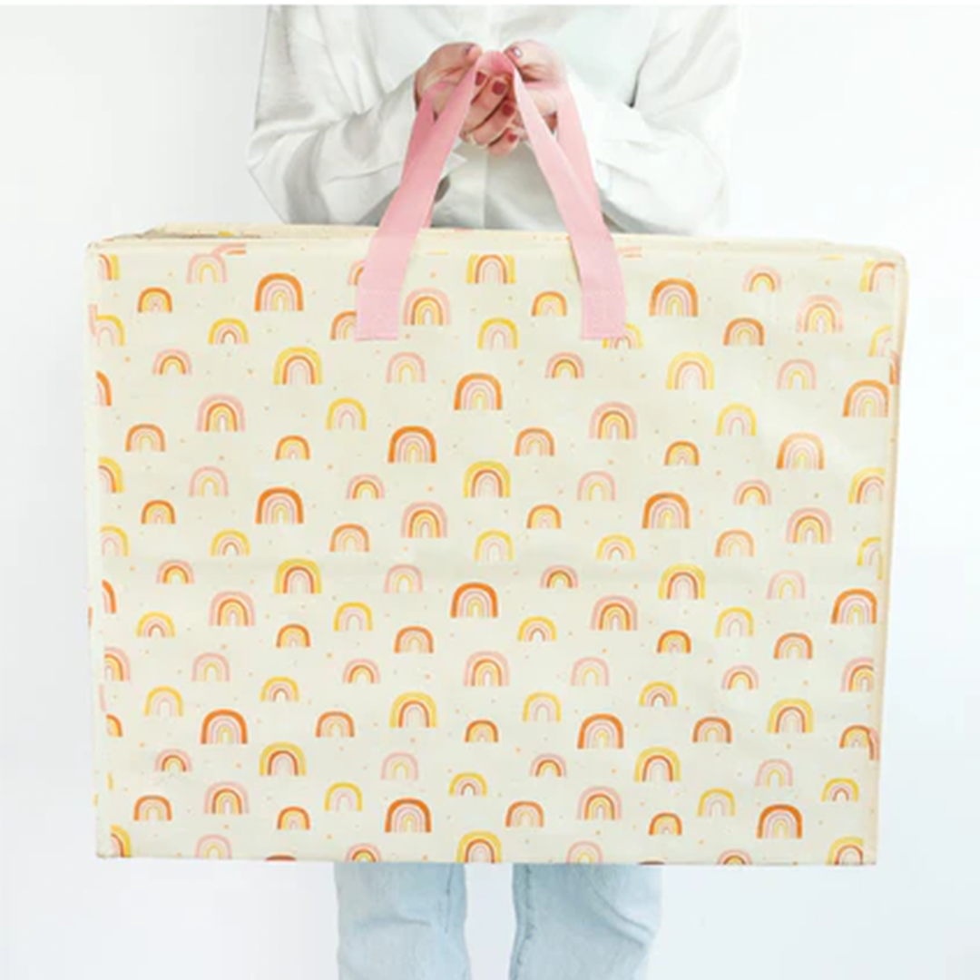 Een persoon draagt de a little lovely company opbergtas met regenboogpatroon.