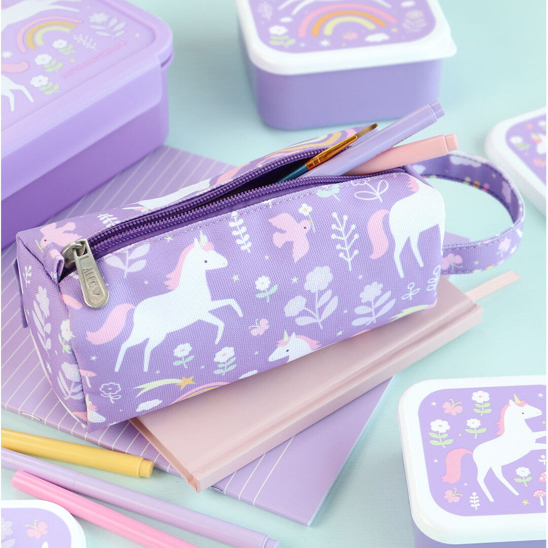 Een open paars pennenetui met eenhoorn- en regenboogpatroon ligt op notitieboeken, omringd door bijpassende lunchboxen.
