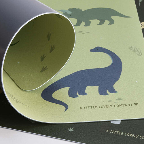 Detail van de A Little Lovely Company groene placemat met dinosaurussen, de hoek is opgerold.
