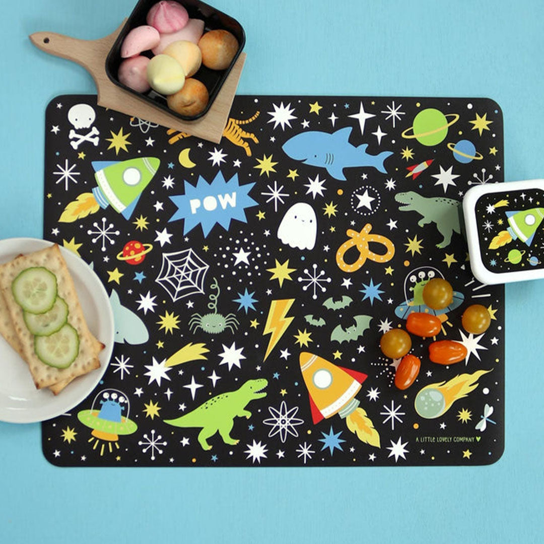Een A Little Lovely Company placemat met galaxy patroon, met daarop snacks en een bijpassende lunchbox.