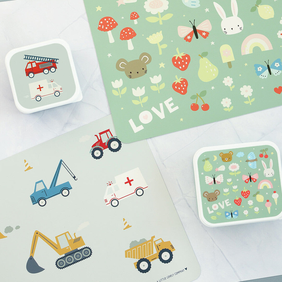 Twee a little lovely company placemats en twee lunchboxen, één met dieren- en bloemenpatroon en één met voertuigen.