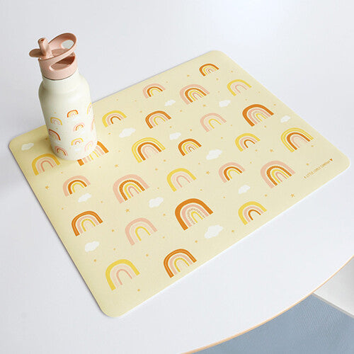 A little lovely company placemat met regenbogen en sterren op een witte tafel, met een bijpassende drinkfles erop.