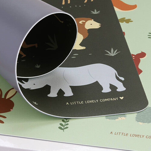 Detailfoto van de a little lovely company placemat met safari dieren, waarbij de hoek is opgerold en de lichtgroene onderkant zichtbaar is.