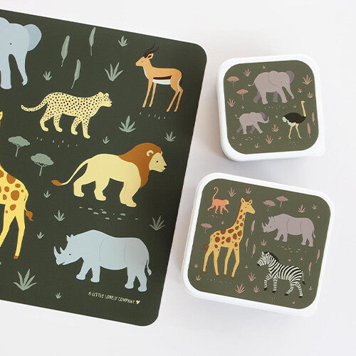A little lovely company placemat met safari dieren, naast twee bijpassende lunchboxen met hetzelfde thema.
