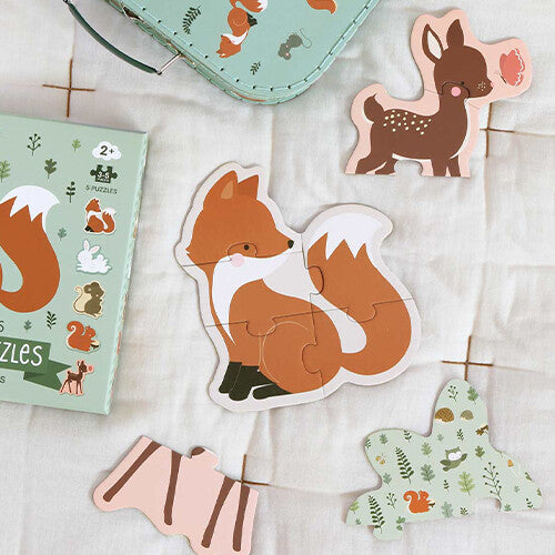 Een a little lovely company kinderpuzzel van een vos, deels in elkaar gezet op een witte ondergrond, met de verpakking en andere puzzelstukken op de achtergrond.