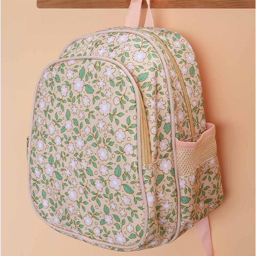 De a little lovely company schoolrugzak met bloemenpatroon hangt aan een houten haak.