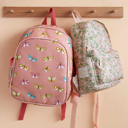Twee a little lovely company schoolrugzakken hangen aan een houten kapstok, één roze met vlinders en één beige met bloemen.