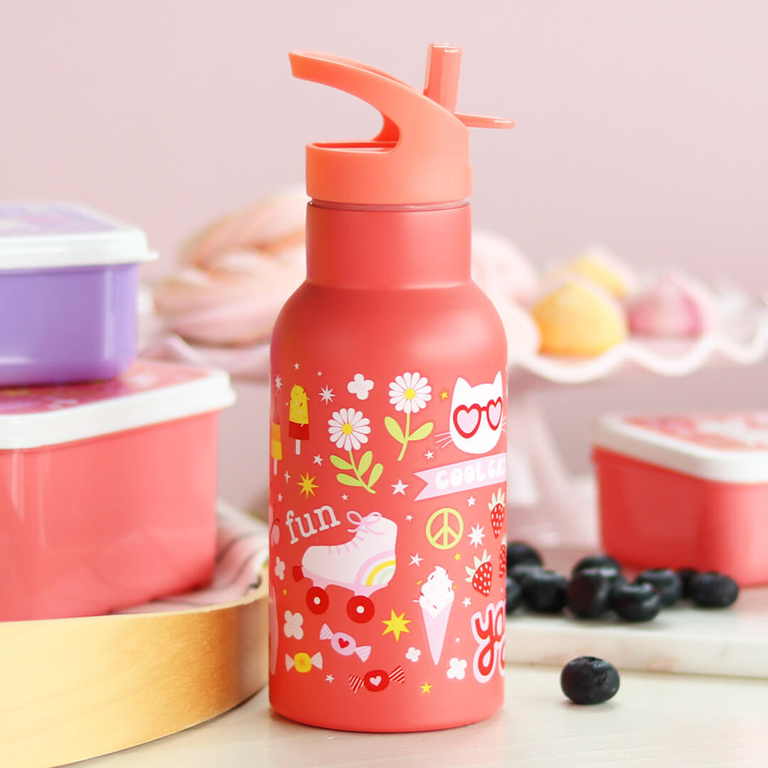 Roze a little lovely company kinderdrinkfles met illustraties van een kat, rolschaats en ijsje, staand tussen roze lunchboxen en blauwe bessen.
