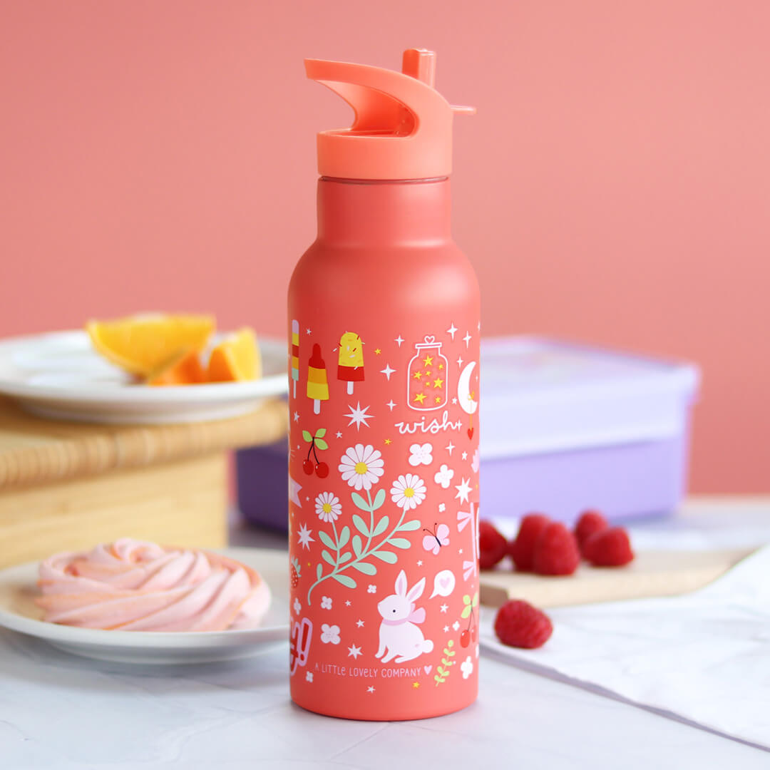 De roze A Little Lovely Company kinderdrinkfles met ijsjes- en konijnenpatroon staat op tafel met fruit en snacks.