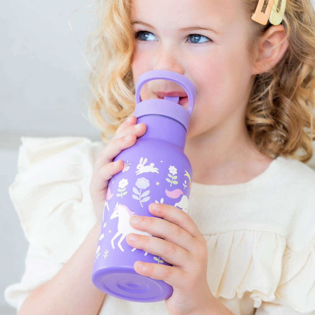 Een meisje drinkt uit de A little lovely company paarse kinder drinkfles met eenhoorn en bloemen.