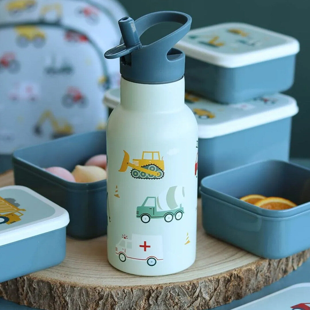 a little lovely company kinderdrinkfles met voertuigenpatroon op een houten schijf, omringd door bijpassende lunchboxen.