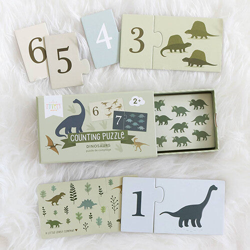 a little lovely company telpuzzel met dinosaurussen, met de open doos en losse puzzelstukken op een witte ondergrond.