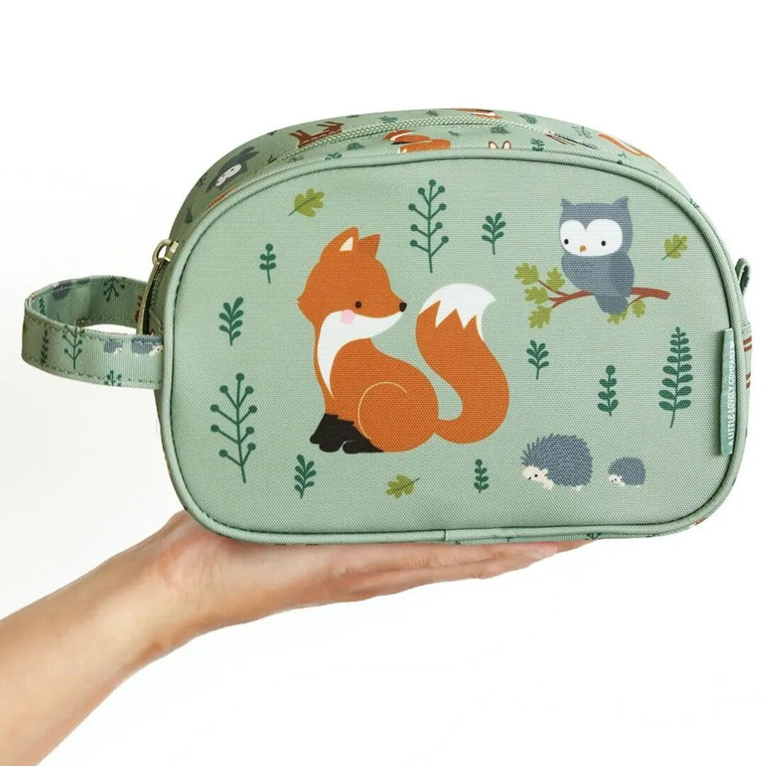Een hand houdt de groene a little lovely company toilettas met bosdierenpatroon vast om de grootte te tonen.