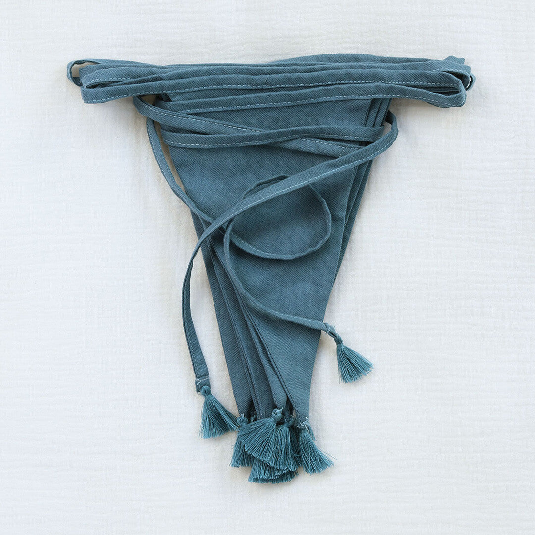 a little lovely company stoffen slinger in vintage blauw, netjes opgevouwen met kwastjes.