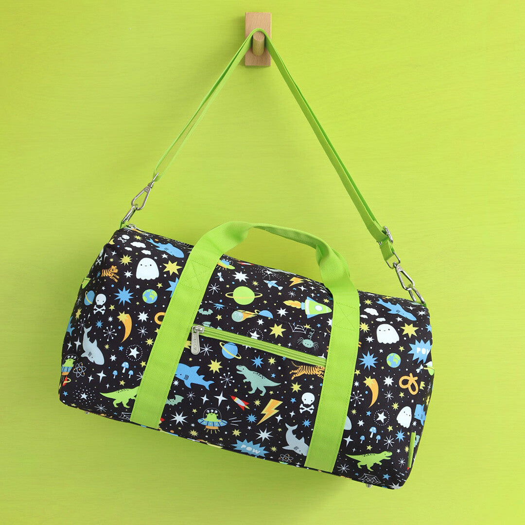 De a little lovely company kinder weekendtas met galaxy patroon en groene schouderband hangt aan een haak.