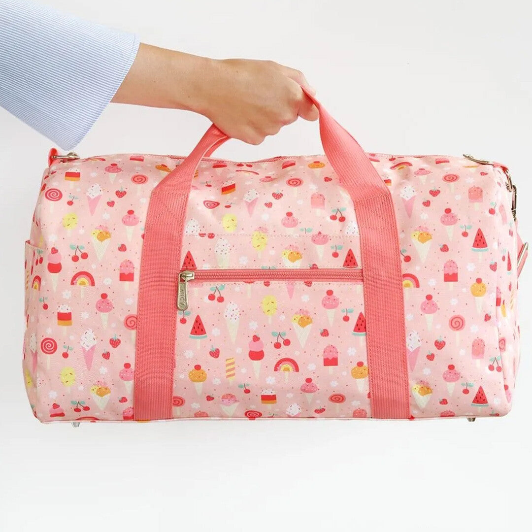 Een hand houdt de a little lovely company kinder weekendtas met ijsjespatroon vast.