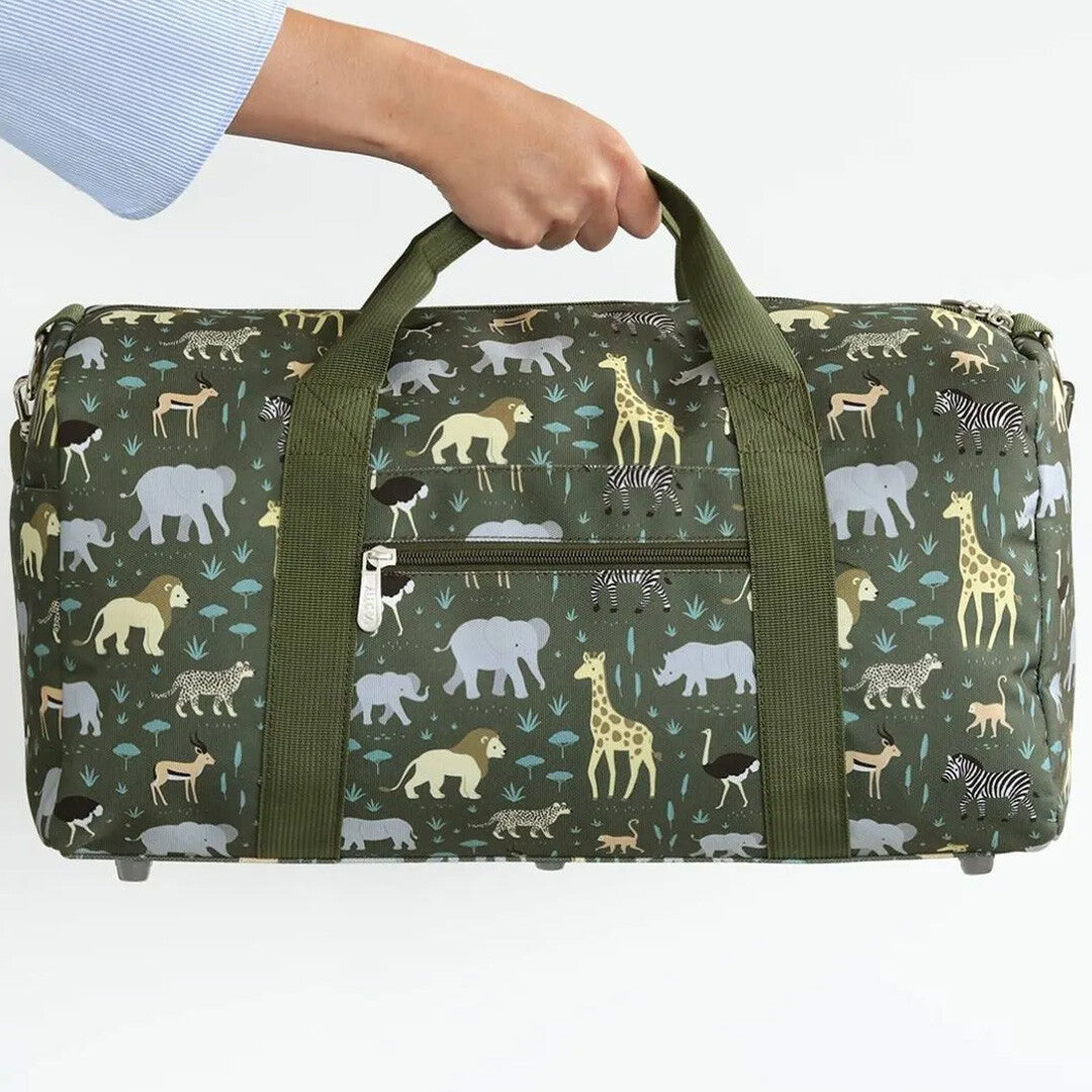 Een hand houdt de a little lovely company groene kinderweekendtas met savannedierenpatroon vast.