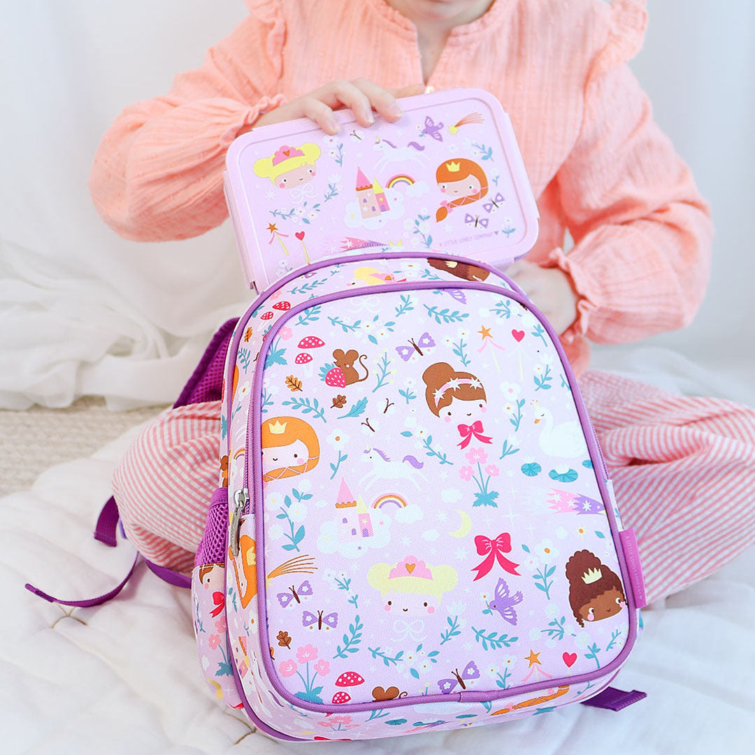 Kind zit met de a little lovely company kinderrugzak met prinsessenpatroon en een bijpassende lunchbox.