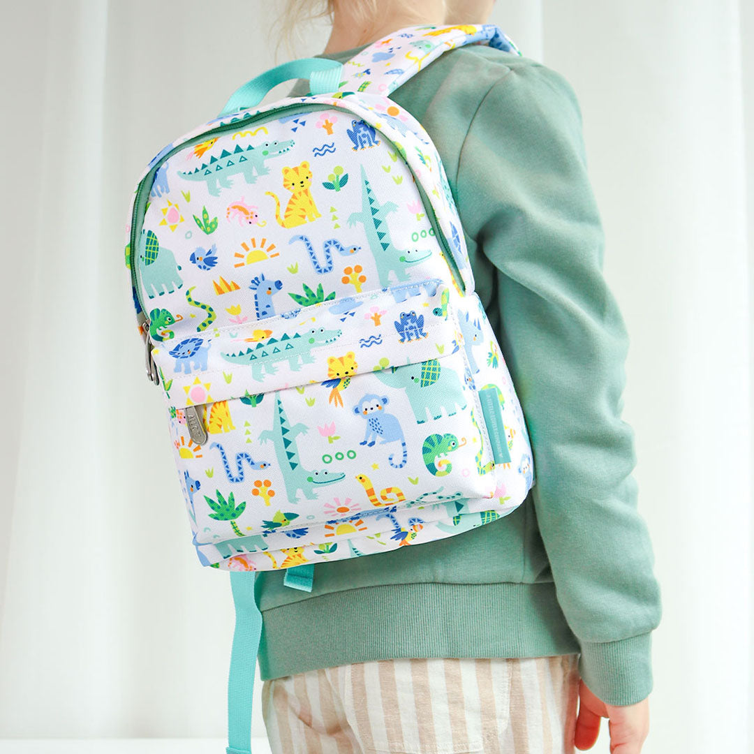 Een kind draagt de a little lovely company kleuterrugzak met jungle dierenprint op de rug.