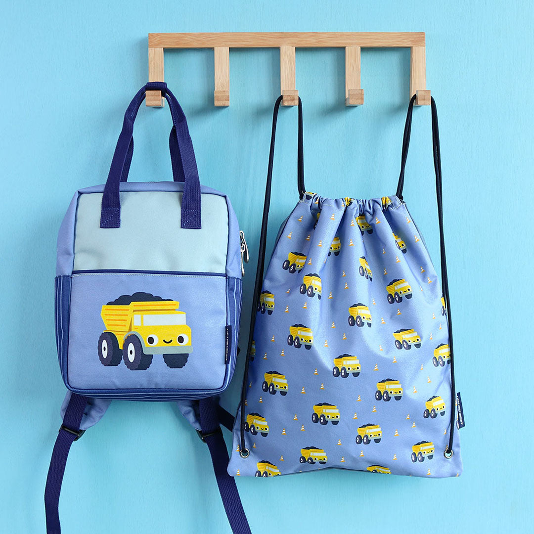 De a little lovely company peuterrugzak met kiepwagen hangt naast een bijpassende gymtas met kiepwagenpatroon aan een kapstok.