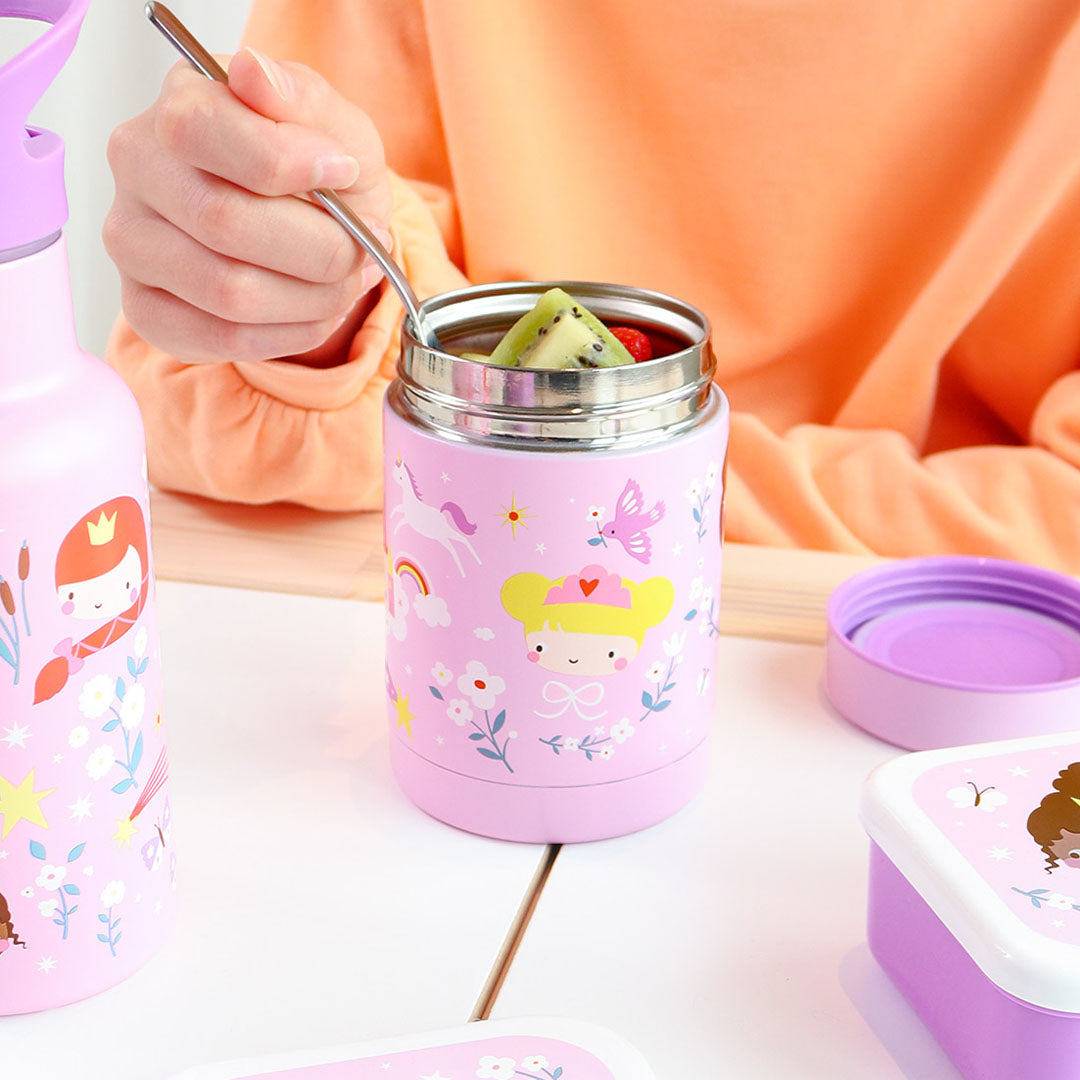 Een kind eet fruit uit de roze RVS voedselpot thermos met prinsessen en een eenhoorn.