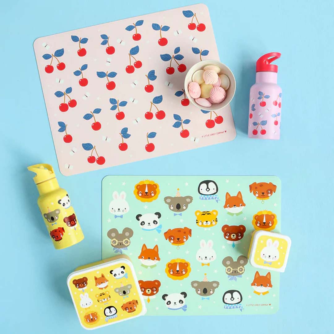 Twee A Little Lovely Company placemats, één roze met kersen en één groen met dieren, met bijpassende drinkflessen en lunchbox.