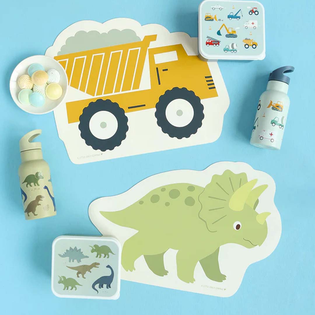 De gele kiepwagen placemat van A Little Lovely Company ligt naast een dinosaurus placemat en bijpassende accessoires.