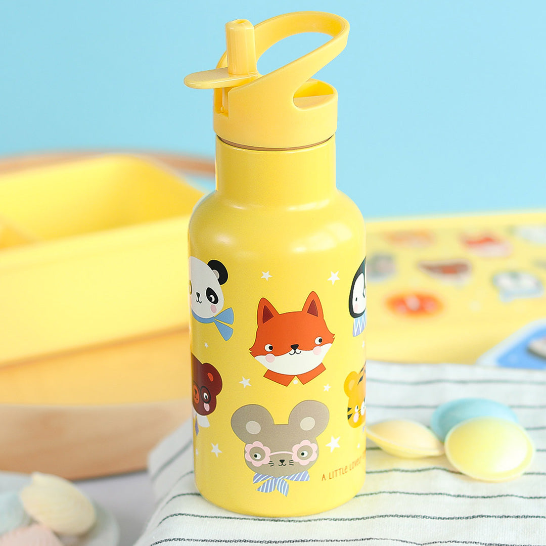Een gele a little lovely company kinder drinkfles met dierenvrienden en sterren op een gestreepte doek.
