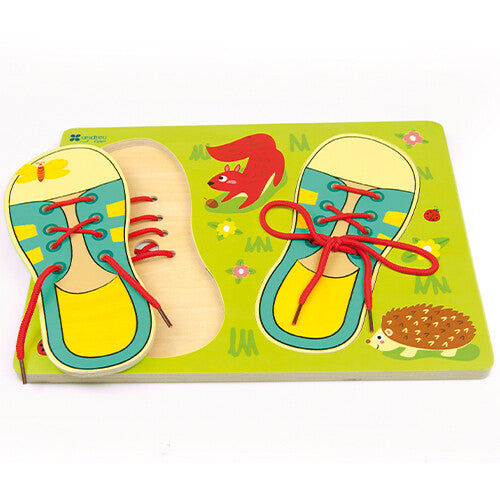 Schuine weergave van de Andreu Toys houten puzzel om veters te strikken, met één schoenstuk deels opgetild.