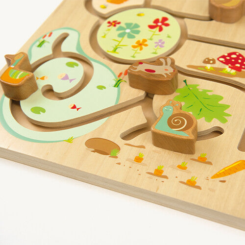 Detail van de houten schuifpuzzel met een konijn en slak op de paden.