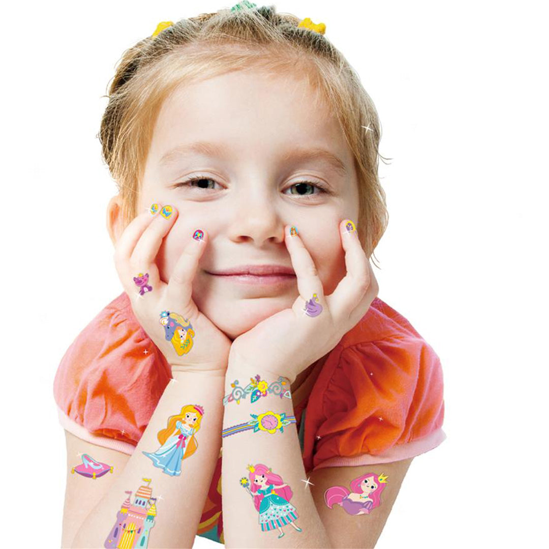 Een lachend meisje met Avenir prinses nagelstickers en tijdelijke tattoos op haar armen en handen.