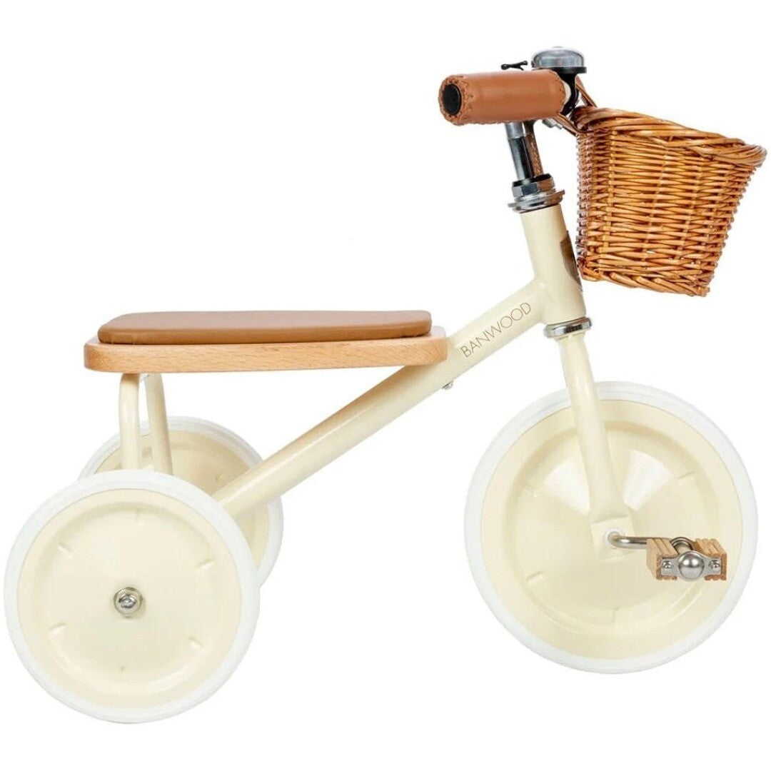 Banwood driewieler in crème met houten zitting, bruine handvatten en rotan mandje.
