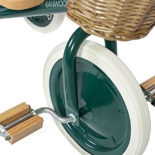 Detail van de houten pedalen en het voorwiel van de groene Banwood driewieler.