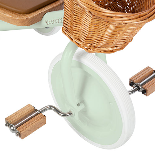 Detail van het voorwiel en de houten pedalen van de Banwood mintgroene driewieler.