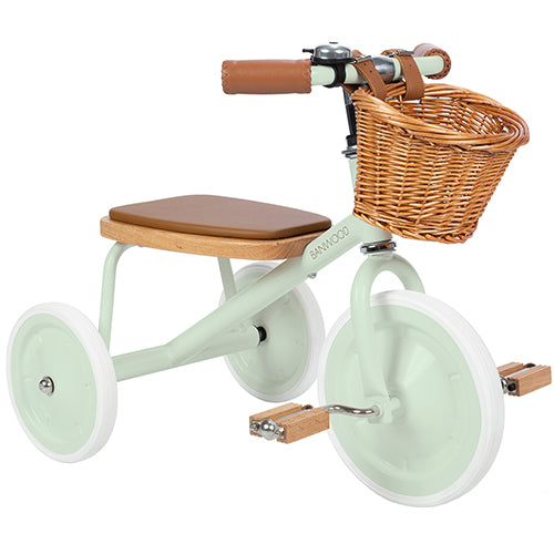 Banwood mintgroene driewieler met rieten mandje en houten zitting, schuin van voren gezien.