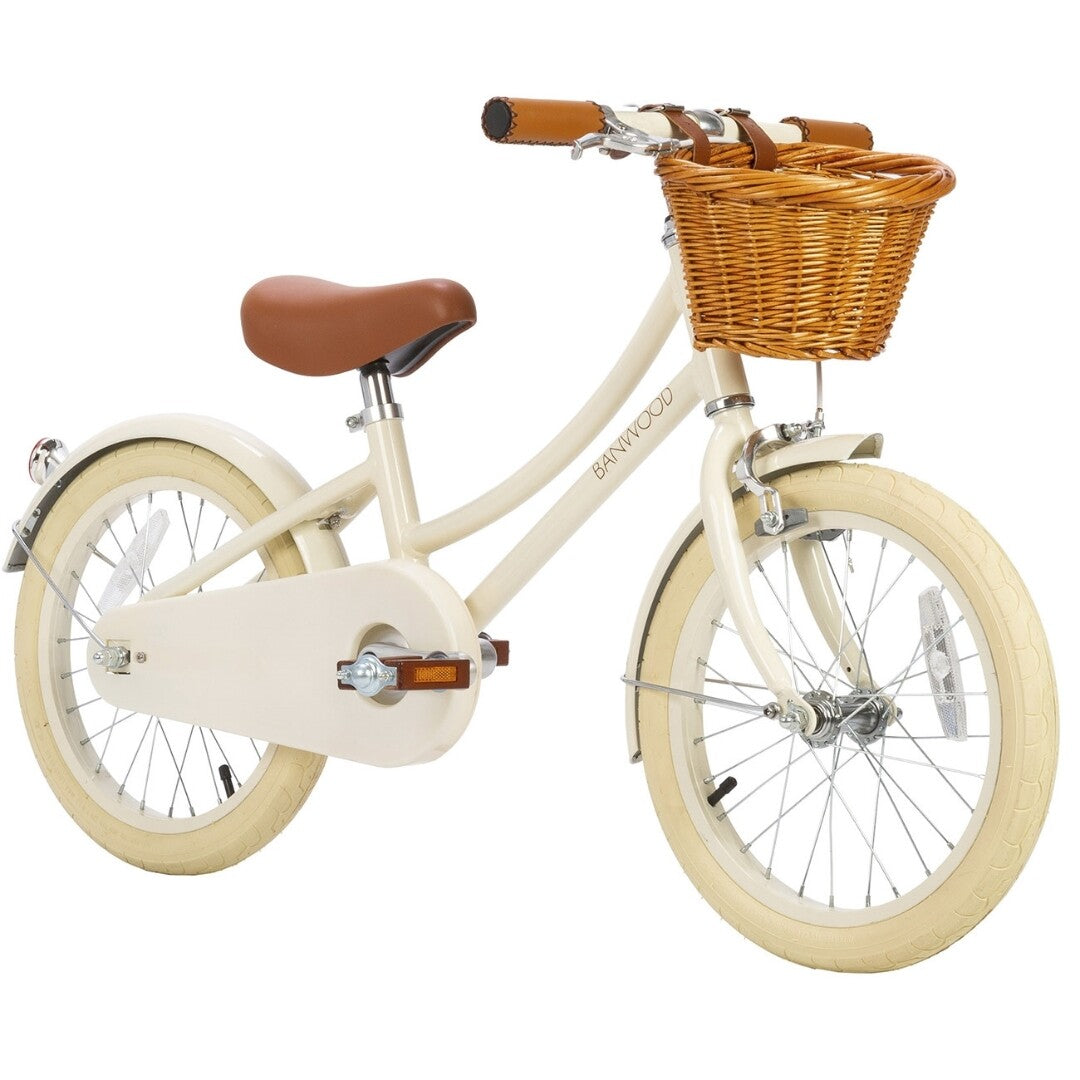 Banwood kinderfiets in crèmekleur met bruin zadel, bruine handvatten en rieten mandje.