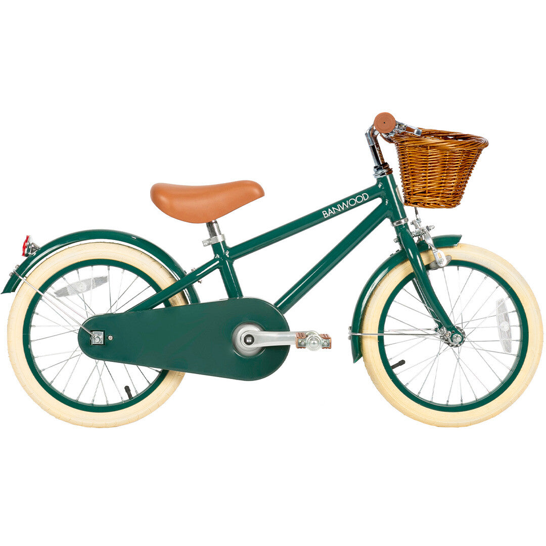 Banwood groene kinderfiets met bruin zadel, crèmekleurige banden en rieten mand, van de zijkant gezien.