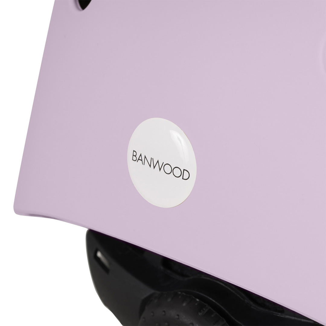 Detail van het Banwood logo op de zijkant van de lavendelkleurige kinderhelm.