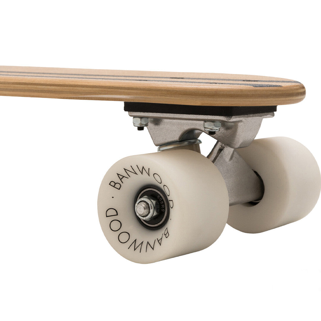 Detail van de trucks en witte wielen van een Banwood kinderskateboard.