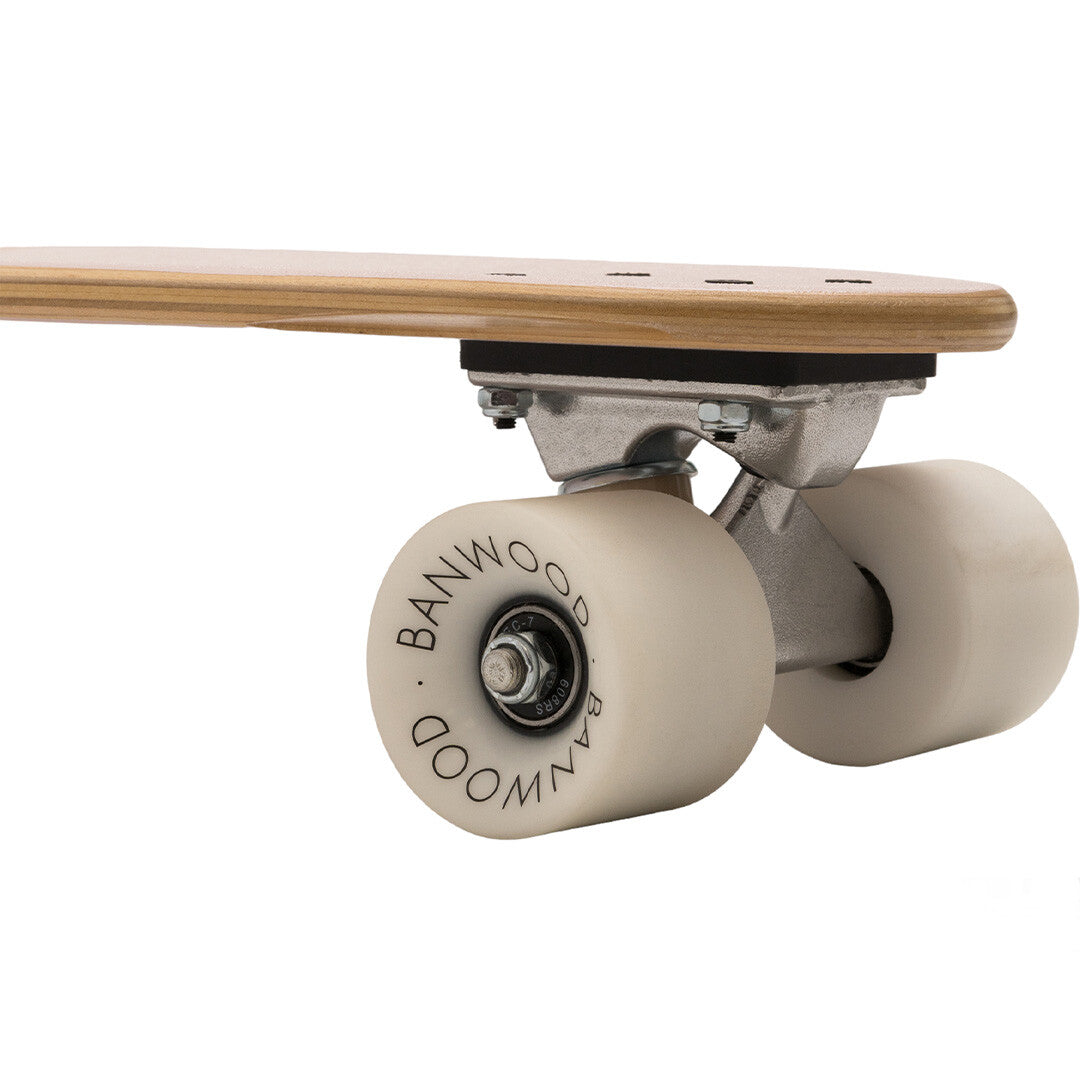 Detail van de witte Banwood wielen en trucks van het kinderskateboard.