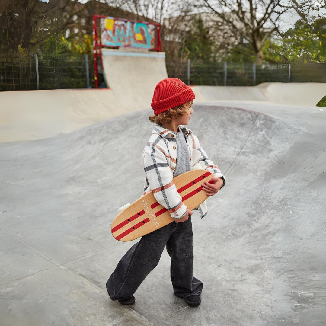 Een kind loopt met het Banwood kinderskateboard in een skatepark.
