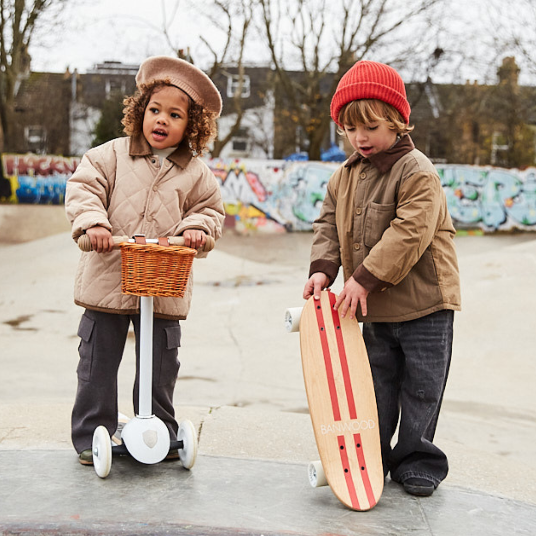 Twee kinderen in een skatepark, één met een scooter en één met het Banwood kinderskateboard.