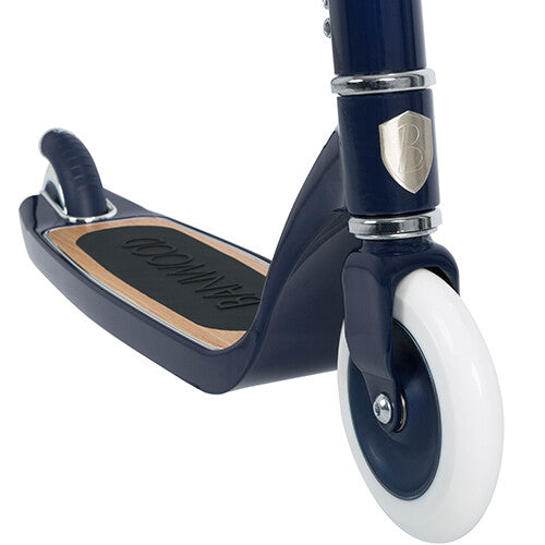 Detail van het voorwiel en de antislip voetenplank van de marineblauwe Banwood kinderstep.