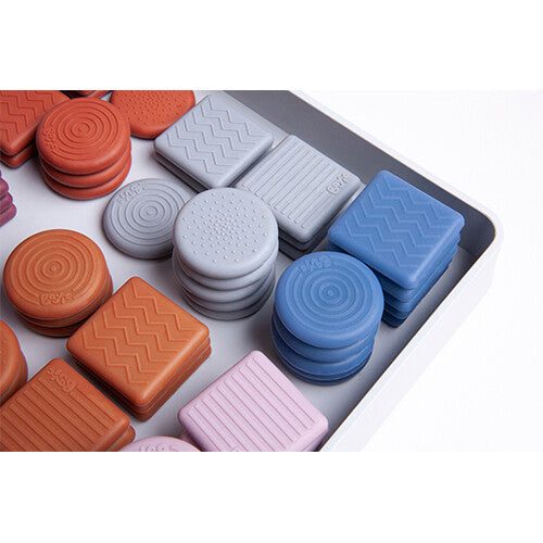 Een detailopname van bavvic siliconen connectors in diverse kleuren en vormen in een witte bak.