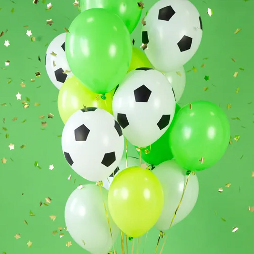 Partydeco collectie van groene en voetbalballonnen met confetti op een groene achtergrond.