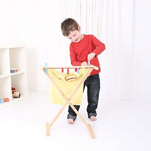 Een kind hangt een geel shirt op aan het Bigjigs houten droogrek speelgoed.