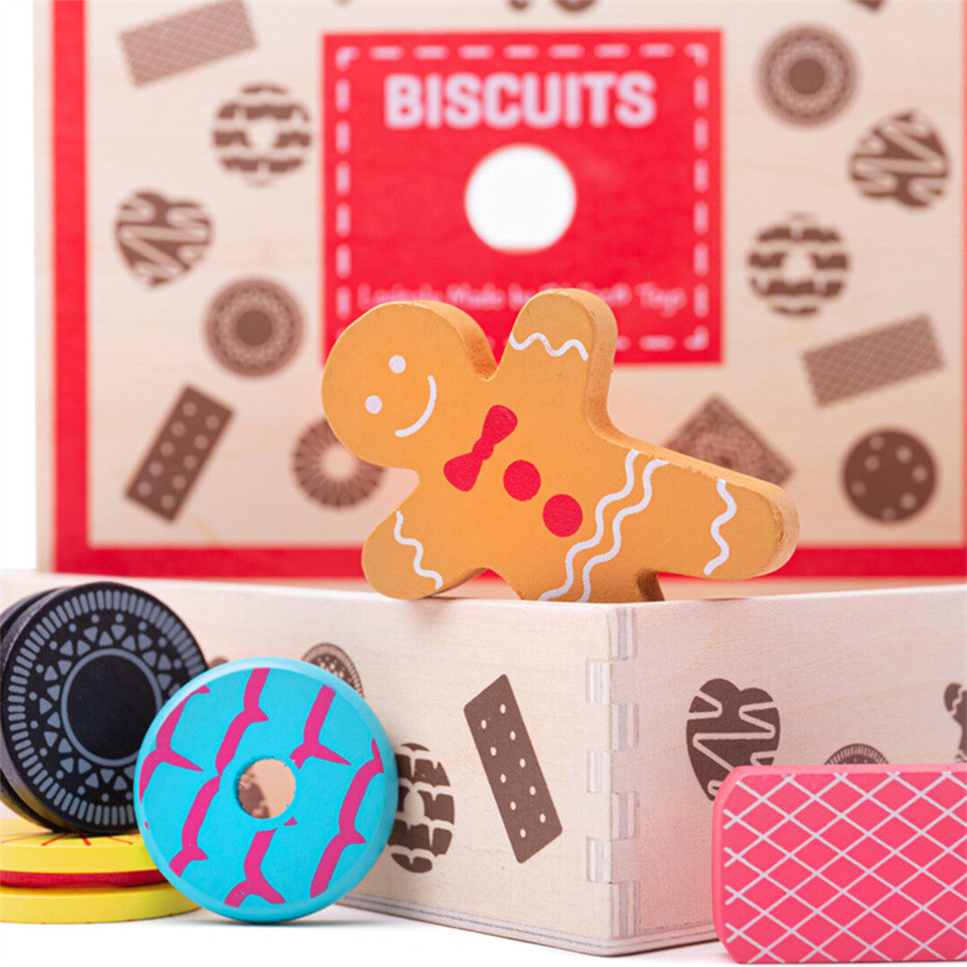 Detail van Bigjigs houten speelgoedkoekjes, waaronder een peperkoekmannetje en een donut, met de gesloten koektrommel op de achtergrond.