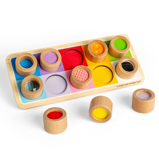 Bigjigs houten sensorisch bord met vijf ingelegde en drie losse houten cilinders met verschillende texturen en kleuren.