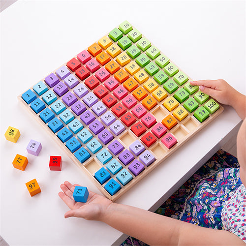 Kind speelt met het Bigjigs houten telbord, waarbij enkele genummerde blokjes uit het raster zijn gehaald.