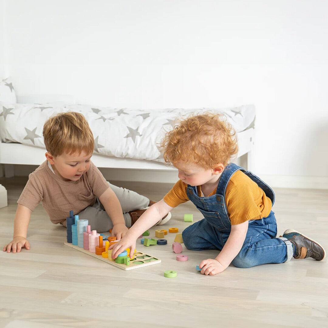 Twee peuters spelen samen met het Bigjigs houten telspel counting board op de vloer.
